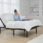 Woman using a laptop on Ergomotion RIO 3.0 Adjustable Bed in a modern bedroom.