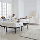 Man and woman lying on Ergomotion RIO 4.0 Adjustable Bed in a modern bedroom.
